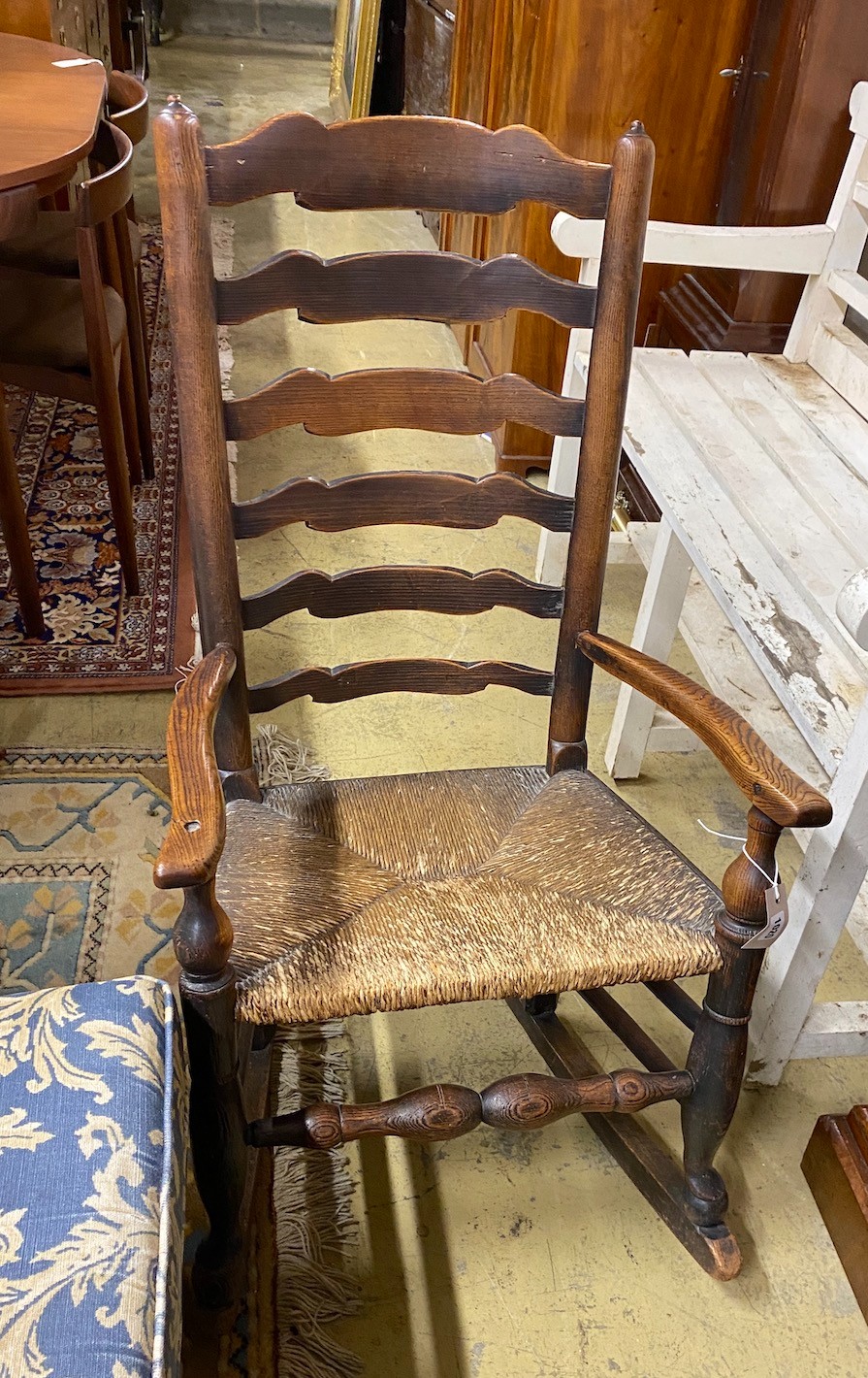 A 19th century Lancashire rush-seated ladder back rocking chair, width 54cm, depth 38cm, height 99cm